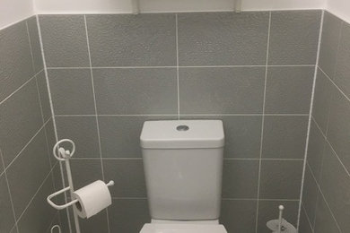 Exemple d'un WC et toilettes romantique de taille moyenne avec WC à poser, un carrelage gris, des carreaux de céramique, un mur blanc, un sol en carrelage de céramique, un plan vasque et un sol blanc.