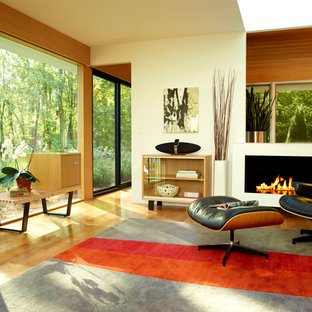 Inspiration för ett funkis vardagsrum, med beige väggar och en bred öppen spis