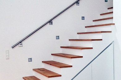 Gerade Klassische Holztreppe mit Beton-Setzstufen und Stahlgeländer in Frankfurt am Main