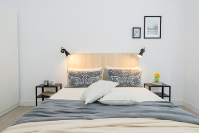 Imagen de dormitorio principal y blanco y madera actual de tamaño medio con paredes blancas y suelo de madera clara