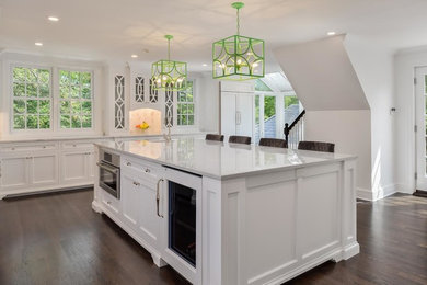 Inspiration for a large transitional l-shaped dark wood floor and brown floor eat-in kitchen remodel in New York with an undermount sink, recessed-panel cabinets, white cabinets, marble countertops, beige backsplash, marble backsplash, paneled appliances and an island