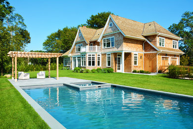 Inspiration for a large timeless brown two-story wood exterior home remodel in New York with a shingle roof