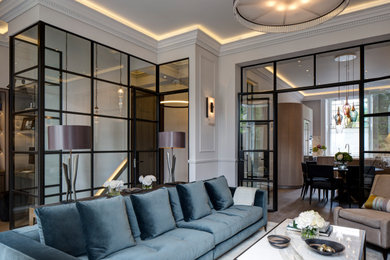Photo of a medium sized industrial formal enclosed living room in London with white walls, medium hardwood flooring, brown floors and panelled walls.