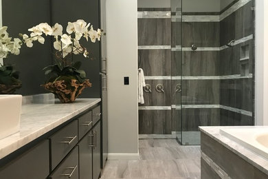 Bathroom - large modern master gray tile and porcelain tile porcelain tile and gray floor bathroom idea in Dallas with flat-panel cabinets, gray cabinets, a two-piece toilet, gray walls, a vessel sink, marble countertops and gray countertops