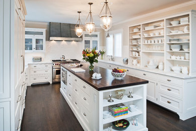 Mid-sized traditional u-shaped eat-in kitchen in New York with beaded inset cabinets, white cabinets, marble benchtops, white splashback, subway tile splashback, stainless steel appliances, dark hardwood floors, with island and an undermount sink.