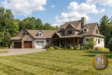 Inspiration for a rustic brown two-story vinyl and board and batten exterior home remodel in Other with a shingle roof and a gray roof