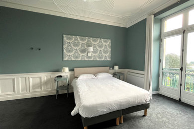 Idée de décoration pour une grande chambre tradition avec un mur bleu, une cheminée standard et un sol gris.