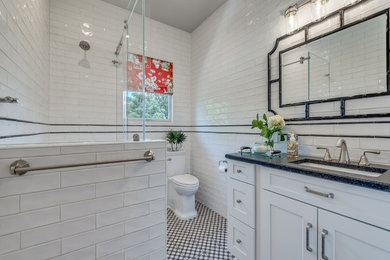 Design ideas for a small traditional kids bathroom in Houston with shaker cabinets, white cabinets, an alcove tub, a shower/bathtub combo, a two-piece toilet, black and white tile, subway tile, white walls, porcelain floors, an undermount sink, granite benchtops, black floor, a sliding shower screen and black benchtops.
