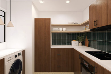 Réalisation d'une cuisine design en L et bois brun fermée et de taille moyenne avec un évier 1 bac, un placard à porte plane, une crédence verte, un électroménager noir, un sol en terrazzo, aucun îlot, un sol gris, un plan de travail blanc et machine à laver.