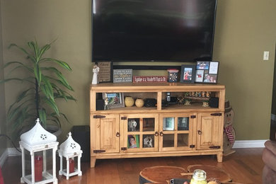 Small mountain style enclosed medium tone wood floor living room photo in Ottawa with beige walls and a tv stand