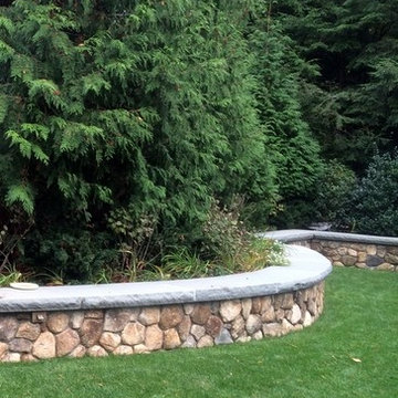New England round stone wall with bluestone cap
