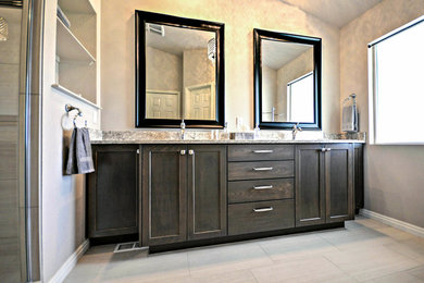 Inspiration for a traditional master bathroom in Boise with shaker cabinets, dark wood cabinets, beige tile, porcelain floors, granite benchtops, an alcove shower and an undermount sink.