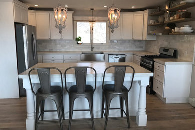 Eat-in kitchen - mid-sized transitional l-shaped ceramic tile and brown floor eat-in kitchen idea in Other with a farmhouse sink, recessed-panel cabinets, white cabinets, quartz countertops, gray backsplash, ceramic backsplash, stainless steel appliances, an island and gray countertops