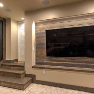 Diseño de sótano en el subsuelo rústico, grande, con paredes marrones, moqueta, chimeneas suspendidas, marco de chimenea de baldosas y/o azulejos y suelo beige