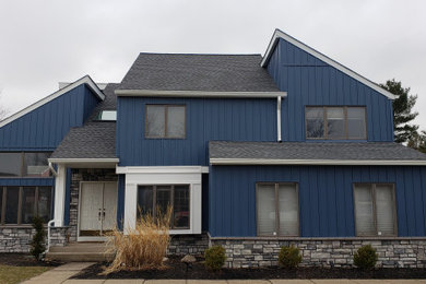 Inspiration for a large blue two-story vinyl house exterior remodel in Philadelphia with a shingle roof and a gray roof