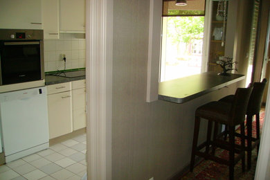Foto de cocinas en L contemporánea grande abierta con puertas de armario beige, electrodomésticos de acero inoxidable y una isla