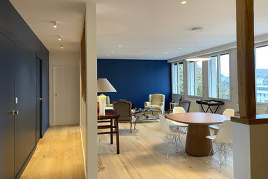 Inspiration pour une grande salle de séjour design avec un mur bleu et parquet clair.