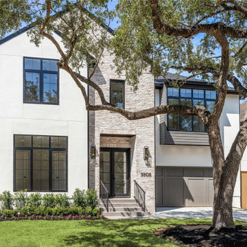 West University custom home with mixed stone and brick facade and black steel wi