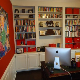Photo of a small modern study in Indianapolis with red walls, dark hardwood flooring, no fireplace and a freestanding desk.