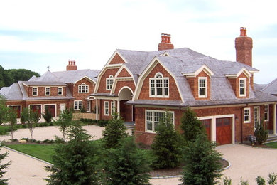 Example of a huge classic brown two-story brick exterior home design in New York with a gambrel roof