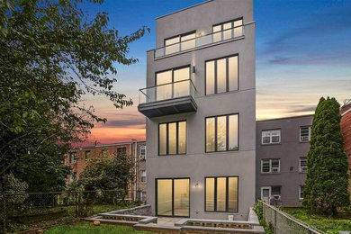 Large minimalist gray three-story concrete exterior home photo in New York