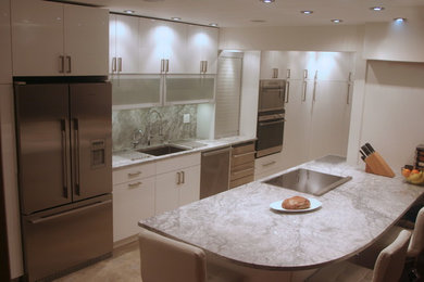 Eat-in kitchen - modern u-shaped eat-in kitchen idea in Vancouver with an undermount sink, flat-panel cabinets, white cabinets, quartzite countertops, stone slab backsplash and stainless steel appliances