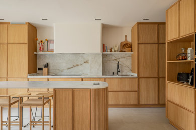 Imagen de cocina contemporánea con electrodomésticos negros, una isla y encimeras blancas