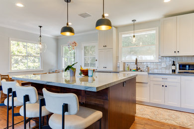 Kitchen - l-shaped medium tone wood floor and brown floor kitchen idea in Los Angeles with a farmhouse sink, shaker cabinets, blue backsplash and an island