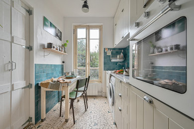 パリにあるお手頃価格の小さなミッドセンチュリースタイルのおしゃれなコの字型キッチン (アンダーカウンターシンク、セラミックタイルの床) の写真