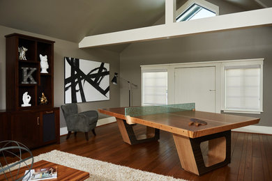 Large 1960s open concept medium tone wood floor and brown floor game room photo in Los Angeles with gray walls and no fireplace