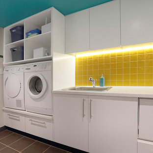 Design ideas for a medium sized contemporary single-wall separated utility room in Sydney with a built-in sink, flat-panel cabinets, white cabinets, laminate countertops, ceramic flooring and a side by side washer and dryer.