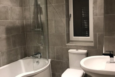 Foto de cuarto de baño infantil contemporáneo de tamaño medio con bañera empotrada, baldosas y/o azulejos de cerámica, paredes grises, suelo de baldosas de cerámica y suelo gris