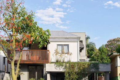 Inspiration for a contemporary two-storey stucco beige house exterior in Brisbane with a metal roof, a grey roof and board and batten siding.