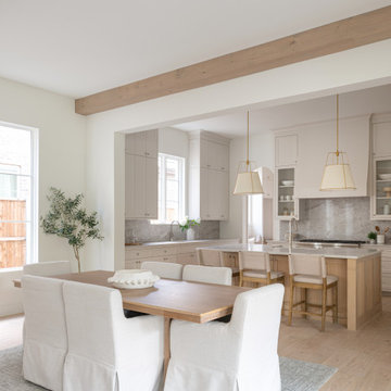 Open dining area flowing into the kitchen beneath exposed wood beams