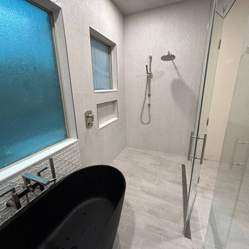 Curbless shower with a freestanding bathtub