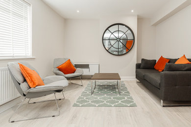 This is an example of a medium sized industrial open plan living room in Other with white walls, light hardwood flooring, no fireplace and no tv.