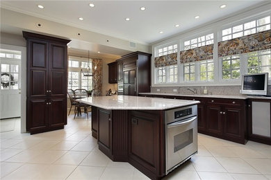 Inspiration for a large timeless u-shaped porcelain tile and white floor eat-in kitchen remodel in Las Vegas with an undermount sink, raised-panel cabinets, dark wood cabinets, granite countertops, multicolored backsplash, stone slab backsplash, stainless steel appliances, an island and multicolored countertops