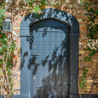 ロンドンの中サイズの片開きドアトラディショナルスタイルのおしゃれな玄関ドア (赤い壁、青いドア) の写真