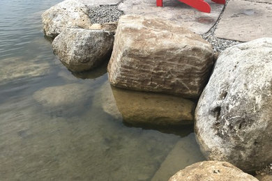 Photo of a small mediterranean full sun backyard stone pond in Other for summer.