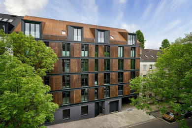 Wohnung mit Metallfassade, roter Fassadenfarbe, Satteldach, Blechdach und rotem Dach in Hamburg