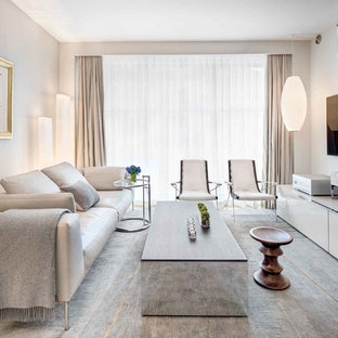 Esempio di un piccolo soggiorno minimal aperto con pareti grigie, moquette, TV a parete e pavimento grigio