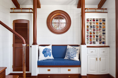 Example of a beach style medium tone wood floor mudroom design in Providence with white walls