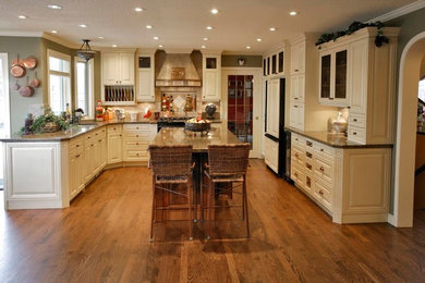 Enclosed kitchen - traditional l-shaped ceramic tile and beige floor enclosed kitchen idea in Calgary with a double-bowl sink, raised-panel cabinets, white cabinets, granite countertops, black backsplash, ceramic backsplash, paneled appliances and a peninsula