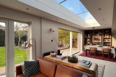 Contemporary open plan dining room with beige walls, ceramic flooring and beige floors.