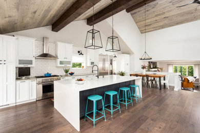 Eat-in kitchen - huge modern single-wall dark wood floor eat-in kitchen idea in Denver with a farmhouse sink, recessed-panel cabinets, white cabinets, quartz countertops, white backsplash, ceramic backsplash, stainless steel appliances, an island and white countertops