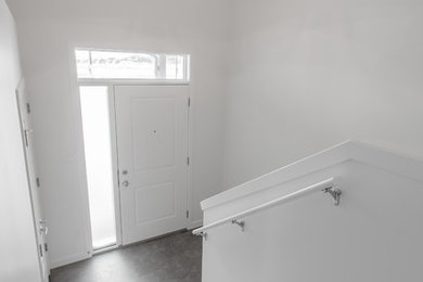 Inspiration for a mid-sized craftsman vinyl floor and gray floor entryway remodel in Calgary with white walls and a white front door