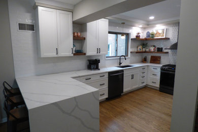 Eat-in kitchen - mid-sized transitional u-shaped light wood floor and brown floor eat-in kitchen idea in Chicago with an undermount sink, shaker cabinets, white cabinets, quartz countertops, multicolored backsplash, porcelain backsplash, black appliances, a peninsula and white countertops