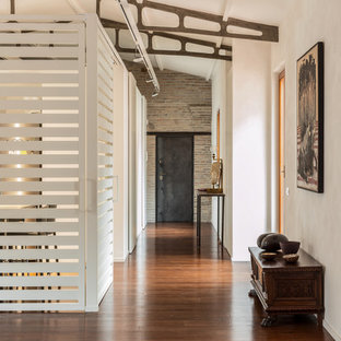 Foto på en mellanstor industriell hall, med vita väggar, brunt golv och mellanmörkt trägolv