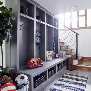 Создайте стильный интерьер: маленький тамбур в стиле рустика с белыми стенами, полом из керамогранита, одностворчатой входной дверью, входной дверью из дерева среднего тона и серым полом - последний тренд