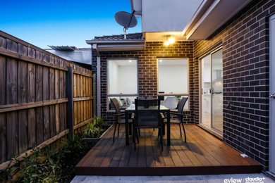 Design ideas for a mid-sized modern backyard and first floor deck in Melbourne.